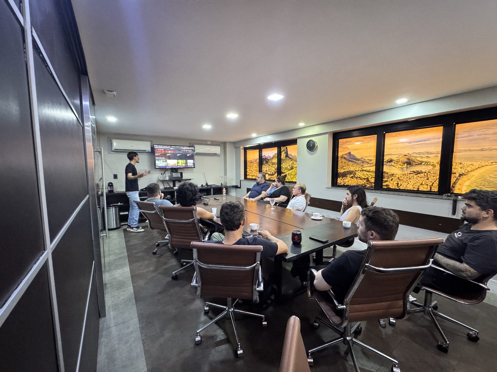 Workshop presencial da LiberEther, com o grupo ao redor da mesa e a apresentação na tela